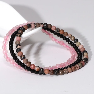 Close-up of 4mm natural amethyst and agate stretch bracelets in pink and black beads