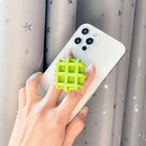 Dettaglio di un supporto per telefono a forma di waffle verde montato su iPhone bianco