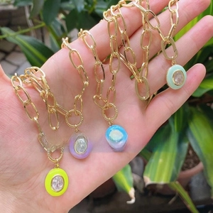 Detail of five colorful enamel oval pendants with gold chain and inset zircon stones