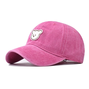 Close-up of pink washed cotton baseball cap with cute white bear embroidery detail