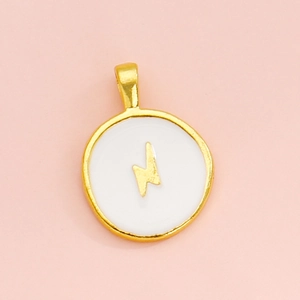 Macro detail of round white enamel pendant with a gold lightning bolt and metal rim