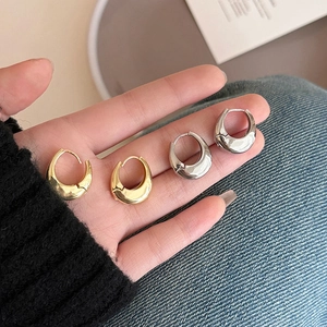 French style teardrop metal hoop earrings in gold and silver finish on hand