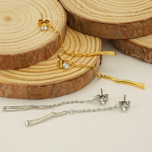 Elegant gold and silver bamboo tassel earrings with zirconia studs on wooden slices