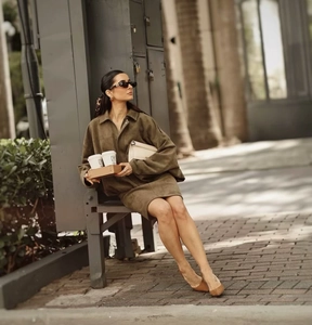 Detail of dark olive suede jacket and skirt set with elegant matte texture and seams