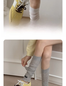 Detail of yellow suede sneaker paired with elastic grey and white knit calf warmers