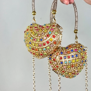 Detail of heart-shaped evening clutch bags with colorful rhinestones and metal chain