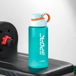 Frosted green 800ml sports water bottle with tea strainer on a gym bench near dumbbells