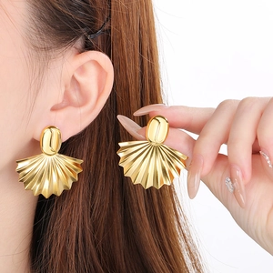 Dettaglio macro di orecchini vintage francesi a ventaglio placcati in oro 18K su modella