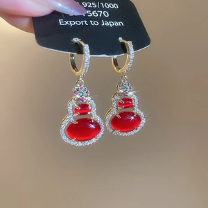 Macro shot of 14k gold plated red resin gourd earrings with zircon pave and colorful gems