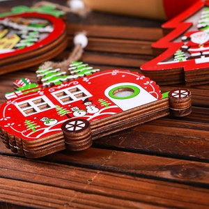 Hollow wooden Christmas ornaments featuring snowman and tree designs on dark wood