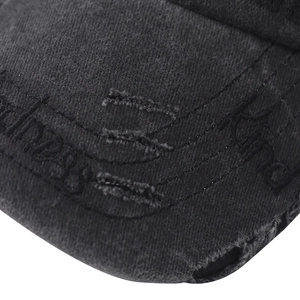 Close-up of distressed brim detail on washed cotton baseball cap with letter embroidery