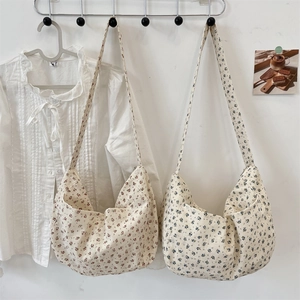 Detail of floral canvas hobo bags in red and blue patterns hanging on a rack