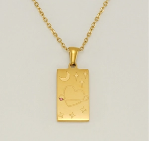 Macro shot of 18K gold plated tarot necklace pendant with engraved moon and pink gemstone
