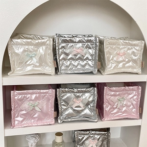 Close-up of heart-quilted PU storage pouches with lace bows in silver, cream and pink
