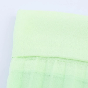 Macro shot of breathable light green cotton gauze fabric texture and detailed hem stitching