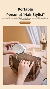 Silver folding hairbrush with mirror being tucked into a stylish brown handbag