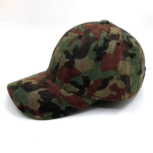 Detail view of camouflage baseball cap showing textured corduroy fabric and stitching