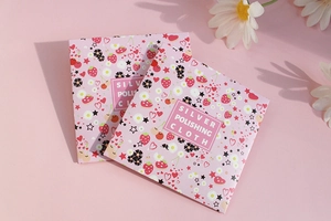 Detailed view of pink floral square silver polishing cloth packaging with white flowers