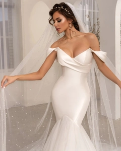 Detailed view of white off-shoulder satin mermaid wedding dress with layered mesh skirt
