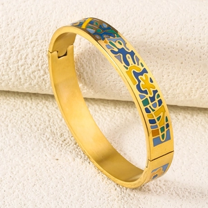 Macro detail of 18K gold-plated stainless steel bangle with colorful enamel geometric patterns