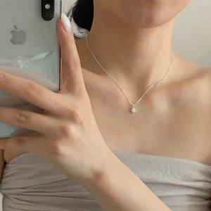 Minimalist 925 sterling silver starburst pendant necklace shown worn on a female neck