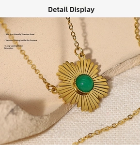 Detailansicht der 18K vergoldeten Blumenhalskette mit einem grünen Edelstein-Inlay