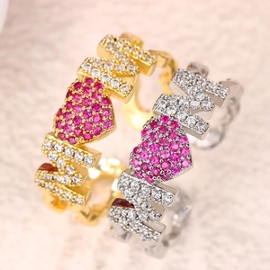 Detailed macro view of gold and silver MOM rings with crystal heart inlay and white stones