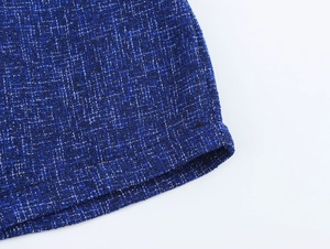 Detail shot of blue tweed fabric texture showing high-quality mixed weave and hem stitching