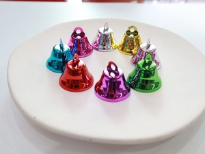 Colorful 26mm matte metal Christmas bells in a white ceramic dish for holiday decoration