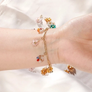 Bracciale dorato in acciaio inossidabile con ciondoli a fiori in cristallo su seta bianca