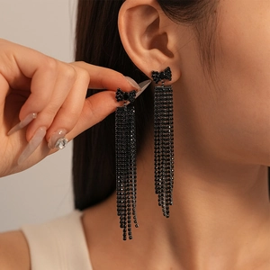 Gros plan de boucles d'oreilles nœud noir avec longues pampilles en strass sur un mannequin