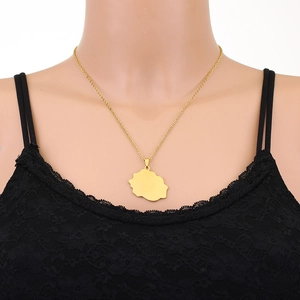 Detailed close-up of a gold Reunion Island map pendant necklace on a black lace outfit