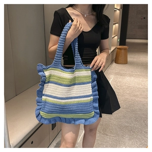 Detail of hand-woven striped crochet tote bag with ruffles and contrast color texture