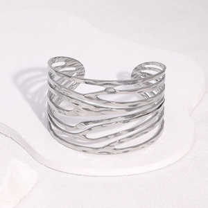 Macro di un bracciale rigido largo in argento con motivi geometrici traforati irregolari