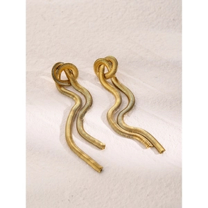 Detailed close-up of gold snake chain tassel earrings with minimalist knotted design