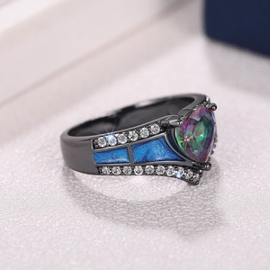 Macro de anillo de gema de corazón oscuro con esmalte azul y detalles de circón