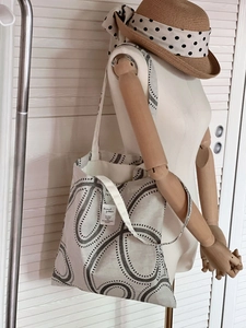 Detailed shot of canvas tote bag with black geometric print and white woven brand label