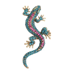 Detail of lizard brooch with blue and pink rhinestones on a gold metal base