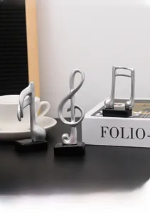 Close-up of matte silver musical note figurines on black bases for desk decor