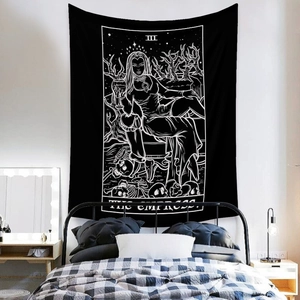 Detail of The Empress tarot tapestry hanging on a white wall above a modern metal bed