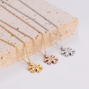 Elegant snowflake pendant necklaces in gold, rose gold and silver finishes on stone