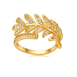 Macro shot of gold feather-shaped ring with pavé-set white zircons and adjustable band