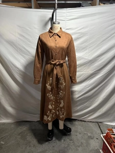 Detailed embroidery on a brown faux suede long-sleeve shirtdress with a waist-tie