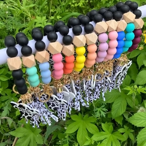 Close-up of silicone bead wristlet keychains with leopard print and Mama cow pendants