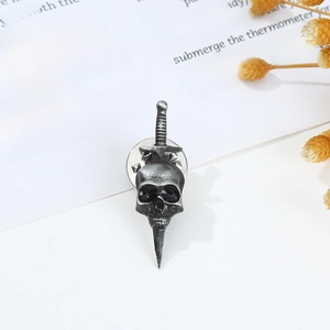 Macro detail of vintage silver punk skull brooch with long sword design on paper background