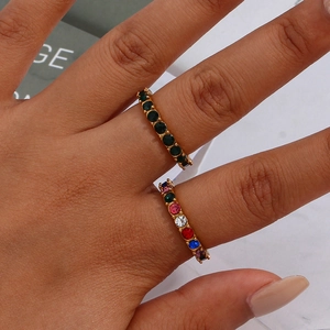 Detailed macro of gold-plated rings with micro-set green and multi-colored zircons