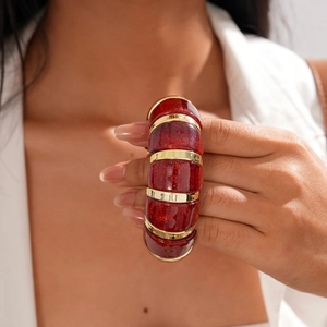 Macro detail of red glitter resin bracelet with gold-plated metal link segments