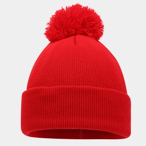 Close-up of red ribbed knit texture and large faux fur pompom detail on the winter hat