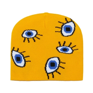 Detail of bright yellow knit beanie featuring unique blue eye jacquard pattern designs