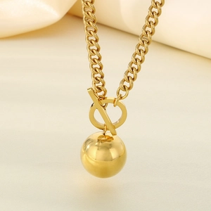 Vue détaillée du collier à chaîne cubaine dorée avec pendentif sphère et fermoir OT
